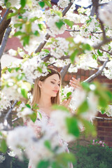 A beautiful girl in a blooming spring garden.