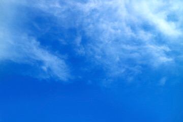White feathery clouds spread on vibrant blue sky