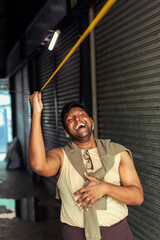 portrait of dark skinned Indian man in Malaysia, with theatrical facial expressions, in the alleyways of the city centre