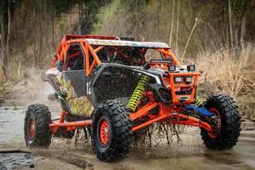 ATV/UTV/4x4 driving throw splashing past a large puddle