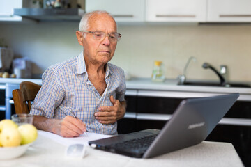 Man having video call with doctor, using laptop at home