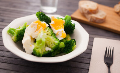 healthy food. steamed broccoli inflorescences with boiled egg in a bowl