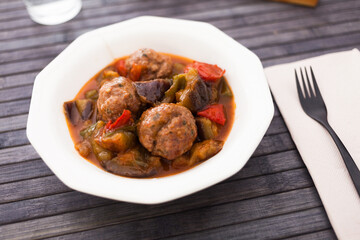 cooked meatballs with stewed eggplant in bowl