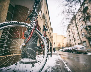 Bicycle in the snow on a winter street in a European city