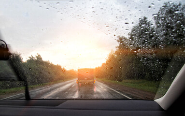 The view from the car through the windshield. Rainy weather, raindrops on glass, overtaking a...