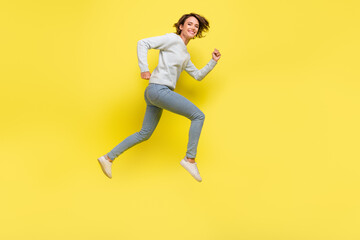 Fototapeta na wymiar Full length profile photo of funny millennial brunette lady run wear pullover jeans sneakers isolated on yellow background