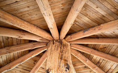Wooden roof vault with large logs in a wooden house, background, architecture