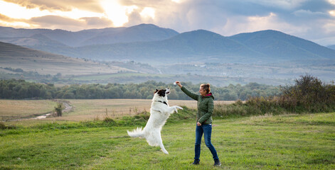 woman and white dog playing outdoors