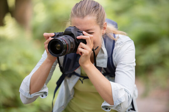 young woman professional photographer taking pictures