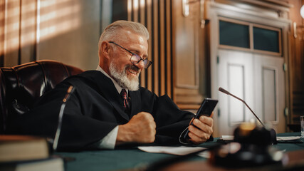 Court of Law and Justice on a Coffee Break: Smiling Judge Having Fun with Smartphone, Playing...