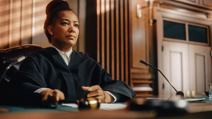 Court of Law Trial in Session: Portrait of Honorable Female Judge Reading Decision. Presiding...