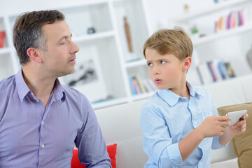 Child trying to prevent father from looking at cellphone