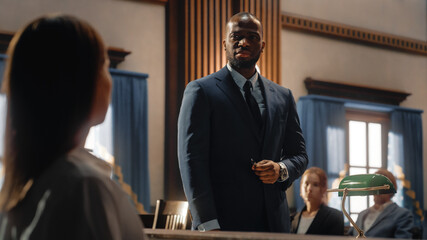 Court of Justice and Law Trial: Male Public Defender Presenting Case, Asking Female Witness in Front of Judge and Jury. African American Attorney Lawyer Protecting Client Against Crime, Injustice.