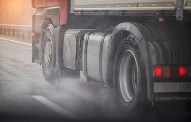Fototapeta na wymiar Truck chassis and wheels on a wet road in rainy weather, close-up. Safety concept and tire grip on wet roads, braking distances under emergency braking