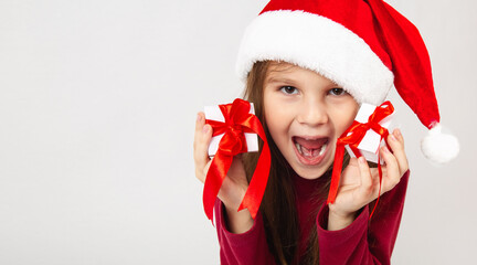 funny happy child girl with gifts boxs for Christmas on a white background. Copy space.