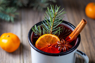 Traditional tasty mulled wine hot drink with mandarin apple spices and christmas tree in white cup - obrazy, fototapety, plakaty