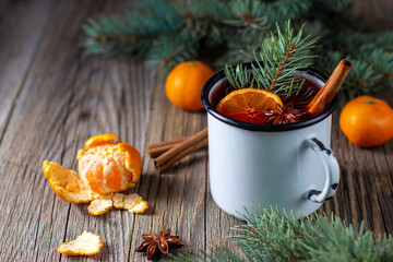 Traditional tasty mulled wine hot drink with mandarin apple spices and christmas tree in white cup