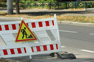 Barricade with road construction sign on city street. Repair works