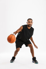 Young black sportsman playing basketball while working out
