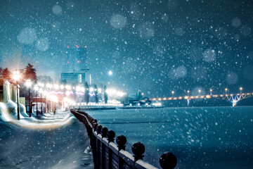 Falling snow against the background of blurry city lights. Humidity background city lights snow...