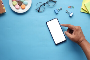 top view of man hand using smart phone on office desk 