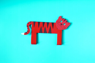 Origami kind orange tiger on a blue background. The symbol of 2022 is a paper tiger close-up