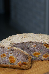 A loaf of baked green buckwheat bread.  A slice of bread has been cut off, a section of a loaf is visible.  Close-up shot.
