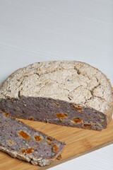 A loaf of baked green buckwheat bread.  A slice of bread has been cut off, a section of a loaf is visible.  Close-up shot.