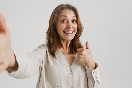 European ginger woman gesturing while taking selfie photo
