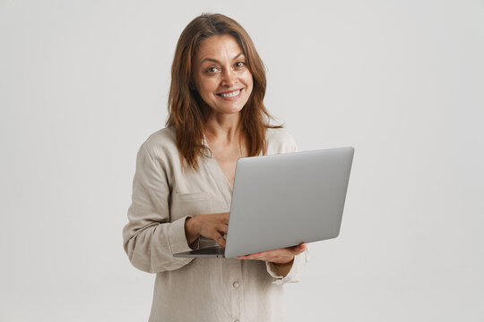 European ginger woman smiling while using laptop