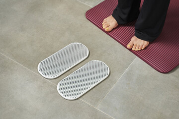 young female beautiful legs stand on the rug opposite the planks with nails. yoga practice
