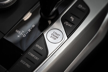 Obraz premium An engine start-stop button of modern luxury sport car. Transportation technology object photo. Close-up and selective focus.
