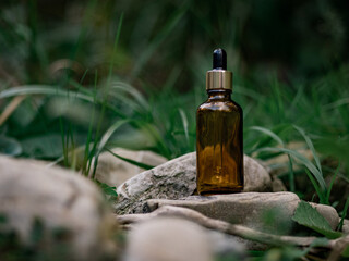 Cosmetic bottle with pipette on natural background