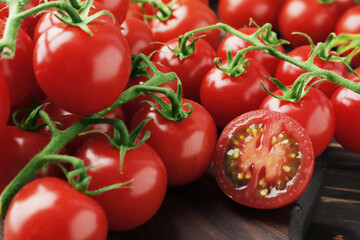 Composition of fresh ripe branches of cherry tomatoes, thyme, basil, rosemary, spices on a wooden textured background