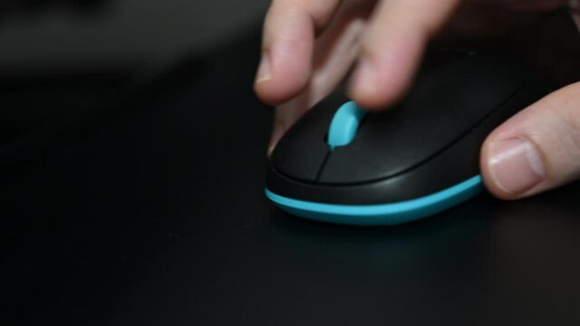 A man is playing games using a bluetooth Logitech mouse.