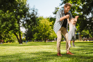 Fototapeta premium Happy mid aged father playing with his little baby son