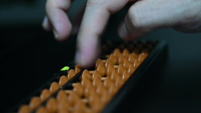 A student is doing mathematics by using abacus calculator.  