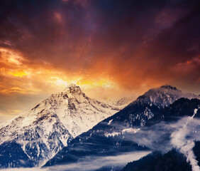 Fototapeta na wymiar Magic sunset in an alpine valley with a snowy peak.