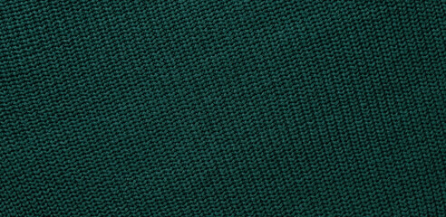 Texture of smooth knitted dark green sweater with pattern. Top view, close-up. Handmade knitting wool or cotton fabric texture. Background of Large Ribs knit pattern with knitting needles or crochet.