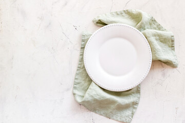 Empty plate on napkin - table setting for dinner. Overhead view