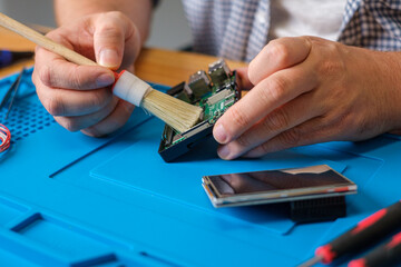 Mini Computer reinigen mit Pinsel - Techniker reinigt PC 