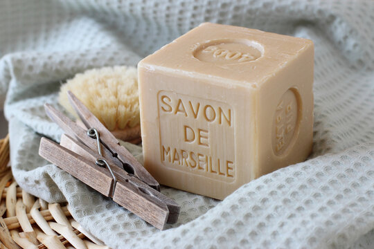 Savon de Marseille sur la serviette en coton avec deux pinces &agrave; linge et brosse en gros plan. Lavage maison. 