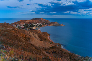 Panorama landscape of the Black Sea coast of Ordzhonikidze village in Crimea, photographed from a high mountain in sunset