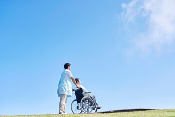 介護士と車椅子に乗る高齢者