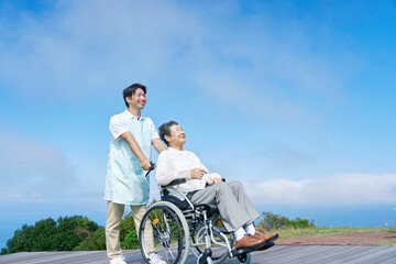 介護士と車椅子に乗る高齢者