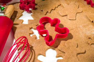 Christmas, New Year cooking background. Baking ingredients and utensils - gingerbread dough, cookie cutters, rolling pin. Making festive Christmas sweet cookies bright festive red white concept