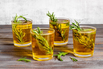 Fefreshing drink of cold tea and rosemary herbs in glasses