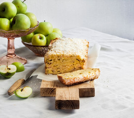 Apple and coconut loaf cake and apples in a vase on a table