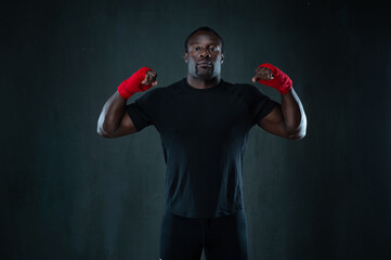 African american muscular athlete in sport uniform over black background. Afro sporty man in boxing...