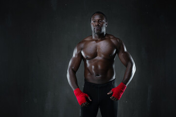 Fototapeta na wymiar African american muscular athlete over black background. Afro sporty man in boxing style. Strength, sport and motion project.